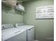 Convenient laundry room with modern washer and dryer, overhead storage, and decorative signage at 00123 Millstream Dr, China Grove, NC 28023