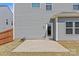 A concrete back patio with a door leading into the house and a gray exterior with vinyl siding at 1062 River Haven Sw Ave, Concord, NC 28025