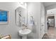 A powder room featuring a pedestal sink, hexagon mirror, and decorative towel ring at 1062 River Haven Sw Ave, Concord, NC 28025