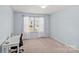 Blue bedroom features a well-lit window, modern carpet, and a bright white desk at 1062 River Haven Sw Ave, Concord, NC 28025