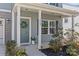 Inviting front porch with gray siding, a wreath on the door, and decorative plants enhancing curb appeal at 1062 River Haven Sw Ave, Concord, NC 28025