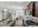 An open kitchen with granite countertops connects to a cozy office area and staircase at 1062 River Haven Sw Ave, Concord, NC 28025