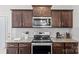 Close-up showcasing stainless steel appliances, granite countertops, and sleek dark wood cabinetry at 1062 River Haven Sw Ave, Concord, NC 28025