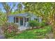 Charming blue home featuring a quaint porch, a well-manicured lawn, and blooming azalea bushes at 1104 Norris Ave, Charlotte, NC 28206