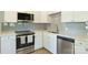 Close up of the kitchen area with stainless steel appliances, white counters and cabinets at 1104 Norris Ave, Charlotte, NC 28206