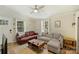 Bright living room with modern fan, sectional couch, hardwood floors, and connecting entry way at 1104 Norris Ave, Charlotte, NC 28206