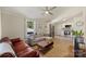 Bright living room with modern fan, sectional couch, hardwood floors, and connecting kitchen at 1104 Norris Ave, Charlotte, NC 28206