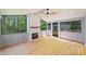 Enclosed sunroom has hardwood floors, a ceiling fan and a cozy fireplace at 1104 Norris Ave, Charlotte, NC 28206