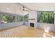 Enclosed sunroom has hardwood floors, a ceiling fan and a cozy fireplace at 1104 Norris Ave, Charlotte, NC 28206