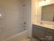 Clean bathroom featuring a tub-shower combo, vanity with sink, and neutral tile flooring at 1119 Overbrook Pl, Wingate, NC 28174