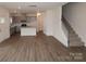 Open-concept living space showcasing wood flooring, stairs, and a view into the modern kitchen at 1119 Overbrook Pl, Wingate, NC 28174