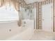 A bathroom featuring a soaking tub, glass shower and floral wallpaper, creating a vintage aesthetic at 113 Rocky Trail Ct, Fort Mill, SC 29715