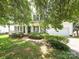 Charming two-story home with white siding, black shutters, covered front porch, and lush landscaping at 113 Rocky Trail Ct, Fort Mill, SC 29715