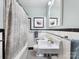 Bathroom with vintage black and white tile, pedestal sink and framed art at 1209 Yale Pl, Charlotte, NC 28209