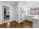 Modern bathroom with hardwood floors, sleek cabinetry, dual sinks, a large mirror, and ample storage space at 1209 Yale Pl, Charlotte, NC 28209