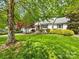 Expansive green front yard with mature trees shading a charming white brick home and landscaped garden at 1209 Yale Pl, Charlotte, NC 28209