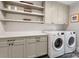 Laundry room with storage cabinets, countertop space, and modern washer and dryer units at 1209 Yale Pl, Charlotte, NC 28209