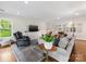Cozy living room featuring hardwood floors, a large window, comfortable seating, and a modern entertainment center at 1209 Yale Pl, Charlotte, NC 28209