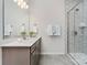 Modern bathroom featuring gray cabinets, quartz countertops, large mirror, and shower with elegant tile work and glass door at 131 Berkeley Ave # D, Mooresville, NC 28117