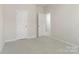 Clean bedroom featuring neutral walls, carpeting, and two doors at 131 Berkeley Ave # D, Mooresville, NC 28117