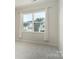 Bright bedroom with natural light coming from the window; neutral walls and carpeting at 131 Berkeley Ave # D, Mooresville, NC 28117