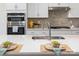 Close-up of the kitchen island with sink, stainless steel faucet, and modern backsplash at 131 Berkeley Ave # D, Mooresville, NC 28117