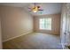 Spacious bedroom featuring a ceiling fan, neutral carpet, and a bright window at 134 Walmsley Pl, Mooresville, NC 28117