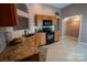 Well-lit kitchen featuring warm wood cabinetry, neutral countertops, and black appliances at 134 Walmsley Pl, Mooresville, NC 28117