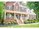 Inviting brick home with a covered front porch, complete with white columns and manicured landscaping at 141 Culpeze Rd, Mooresville, NC 28117
