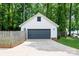 Detached two-car garage with a dark gray door, adjacent to a wooden fence at 141 Culpeze Rd, Mooresville, NC 28117