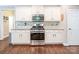 Close up of kitchen area features white cabinets, stainless steel appliances, and hardwood floors at 141 Culpeze Rd, Mooresville, NC 28117