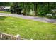 Scenic street view showing lush green lawn, mature trees, and glimpses of the nearby lake at 141 Culpeze Rd, Mooresville, NC 28117