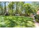 Spacious backyard featuring lush green grass, mature trees, and outdoor grill area at 14812 Stonegreen Ln, Huntersville, NC 28078