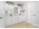 Bright bathroom with dual sink vanity, white cabinetry, and a large framed mirror at 14812 Stonegreen Ln, Huntersville, NC 28078