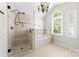 Bright bathroom with a soaking tub and tiled walk-in shower near an arched window at 14812 Stonegreen Ln, Huntersville, NC 28078