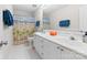Bathroom with dual sinks, white cabinets, and a shower/tub with a themed curtain at 14812 Stonegreen Ln, Huntersville, NC 28078
