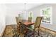 Bright dining room with a chandelier, complemented by an elegant wooden table and beautiful rug at 14812 Stonegreen Ln, Huntersville, NC 28078