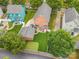 Aerial view showcasing a red house with a manicured lawn and a delightful putting green at 1508 Peaceful Way Dr, Charlotte, NC 28206