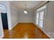 Dining area features wood floors, white trim, a modern light fixture, and access to the outdoors at 1508 Peaceful Way Dr, Charlotte, NC 28206