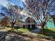Charming two-story home featuring a double porch, red siding, manicured lawn, and detached garage at 1508 Peaceful Way Dr, Charlotte, NC 28206
