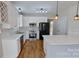 Modern kitchen featuring white cabinets, quartz counters, stainless steel appliances and wooden floors at 1508 Peaceful Way Dr, Charlotte, NC 28206