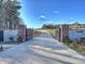 Long driveway entrance featuring an automatic gate flanked by stone and brick columns, and a '1525' sign at 1525 Shinnville Rd, Cleveland, NC 27013