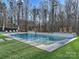 A modern pool is set in a landscaped yard with stepping stones and trees behind it, with lounge chairs for relaxation at 1525 Shinnville Rd, Cleveland, NC 27013