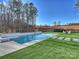 A modern concrete pool is surrounded by lush landscaping and mature trees at 1525 Shinnville Rd, Cleveland, NC 27013
