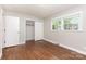 Bedroom with hardwood floors, double windows, closet space, and neutral wall color at 1532 Downs Ave, Charlotte, NC 28205
