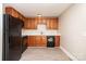 Well-lit kitchen showcasing wood cabinets and black appliances at 1532 Downs Ave, Charlotte, NC 28205