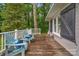 Inviting back porch with wooden flooring, white railing, and light blue adirondack chairs, perfect for relaxing outdoors at 1607 Old Lawyers Rd, Marshville, NC 28103