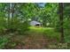 Lush backyard featuring an outbuilding with covered storage, ideal for outdoor projects and storage at 1607 Old Lawyers Rd, Marshville, NC 28103