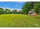 Expansive green backyard featuring a charming red playhouse with a white-picket fence at 1607 Old Lawyers Rd, Marshville, NC 28103