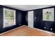 Bedroom with navy walls, hardwood floors, and natural light from the windows at 1607 Old Lawyers Rd, Marshville, NC 28103